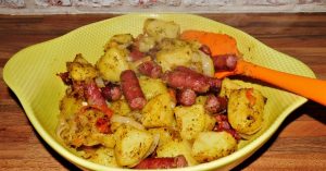 rustic potatoes with game sausages in yellow dish