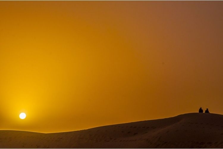 Africa desert sunset, people on dunes